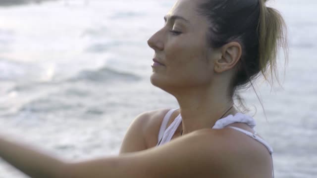 Woman Doing Meditation And Stretching Exercise By The Beach