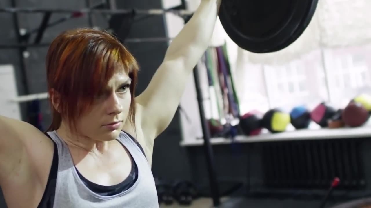 Woman lifting heavy weights in a gym