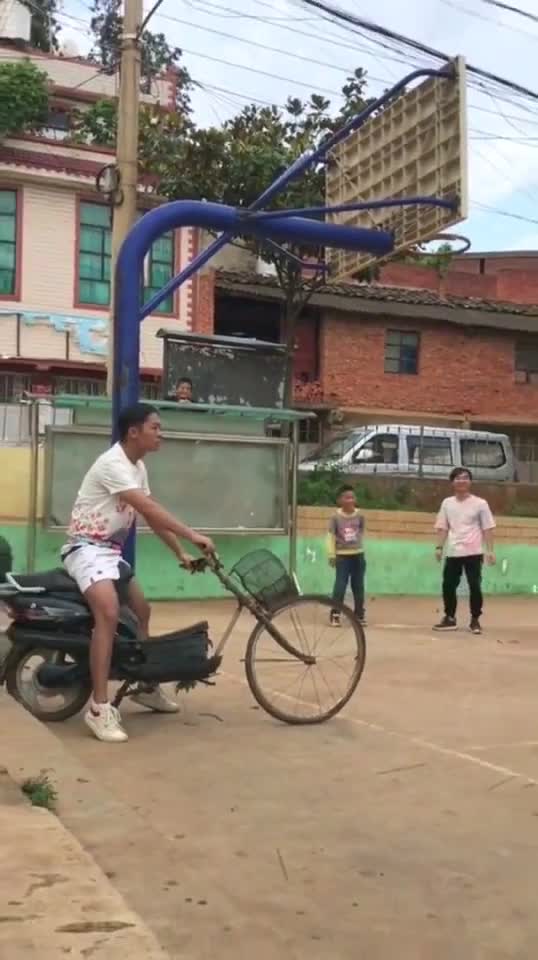 Basketball player jumps and lands on guy's bike tire...poor bike tire