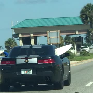 Black car with white board sticking outside the car