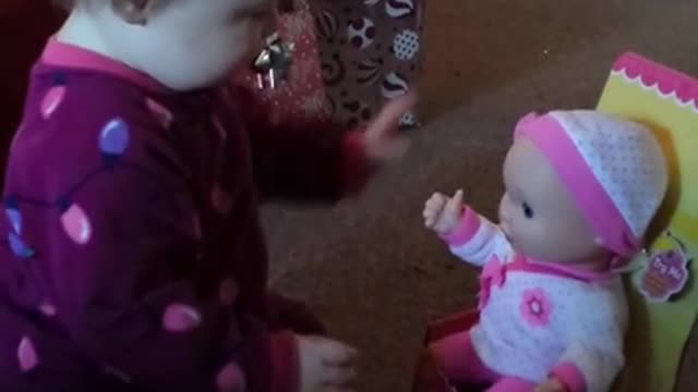 Playful baby has precious reaction to new doll