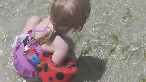 3 year old giggles in the ocean waves