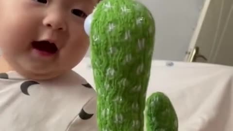 baby playing with cactus