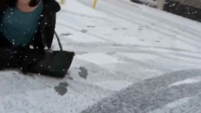 Karma woman tries to push filmer and falls down in snow parking lot