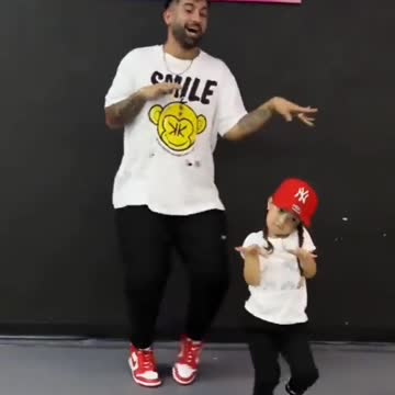 The father and the little girl are dancing