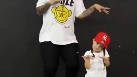 The father and the little girl are dancing