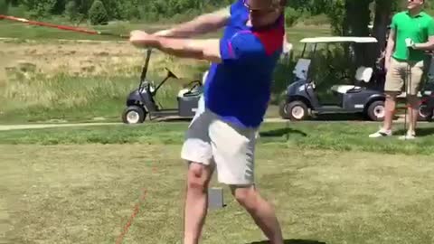 Guy blue shirt drinking beer and playing golf