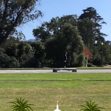 Girl at golden gate park rides a huge motorized skateboard