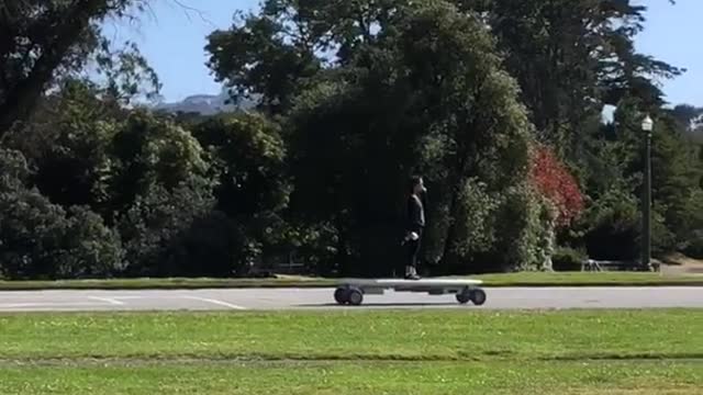 Girl at golden gate park rides a huge motorized skateboard