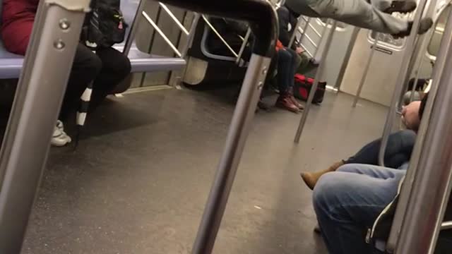 Man does pull ups kicks legs on subway