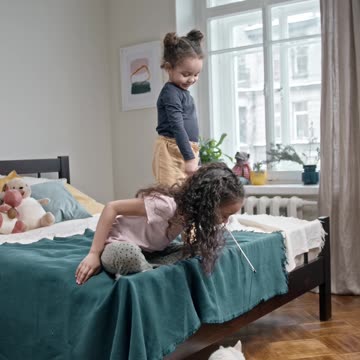 Kids Playing Catch The Bait With Their Cat In The Bedroom