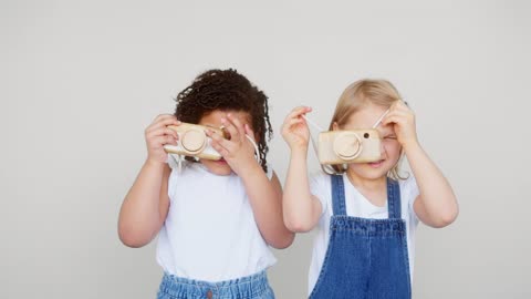 Baby's taking pictures with two toy mobiles