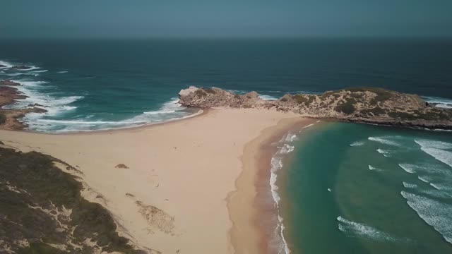 A Seashore Of Sand And Rocky Hills