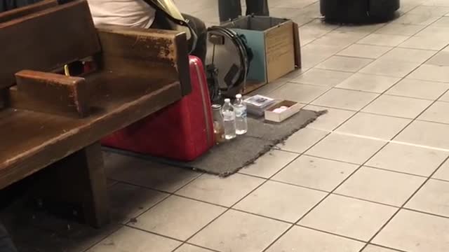 Man in santa hat sining subway station