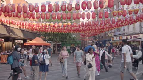 Crowd Of Summer Tourists Walking Through Streets In Chinatown In London England UK