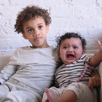 Brothers Sitting on Sofa Together Cry