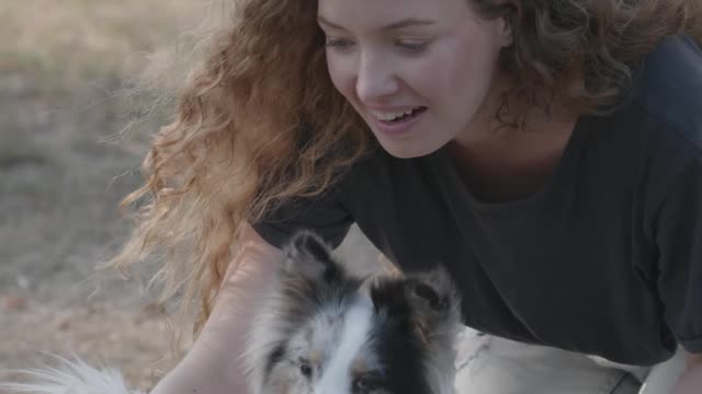 Woman having fun with her cute little puppy