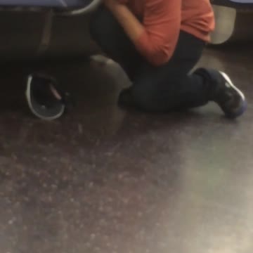 Man in orange shirt face down on seat