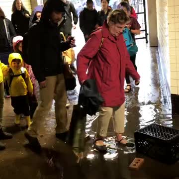 People walking through flooded subway underground tunnel