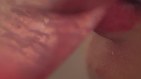 The mouth of a woman taking a cocktail