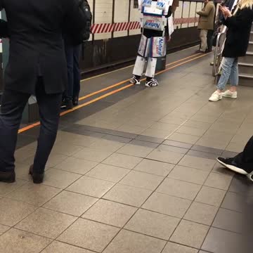 Robot transformers costume made out of beer boxes subway platform