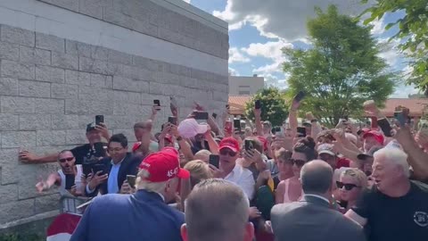 President Donald Trump shakes hands with supporters after