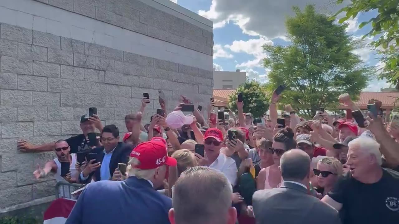 President Donald Trump shakes hands with supporters after