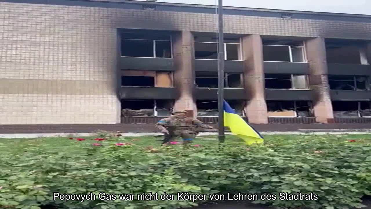 Flagge über Rosine. Auf dem zentralen Platz der befreiten Stadt Präsident Zelenskyi, der Leiter de