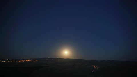 Moonrise in a mountain city landscape