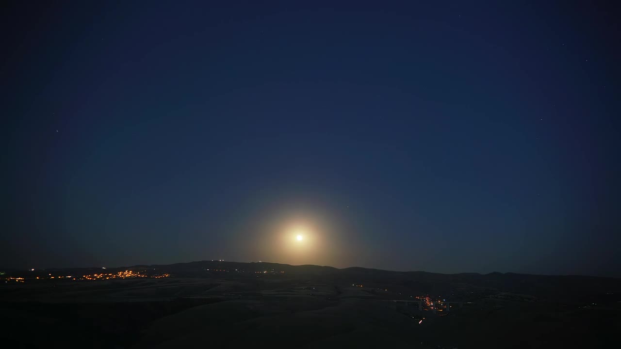 Moonrise in a mountain city landscape