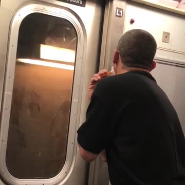 Man in black shirt shaves on subway