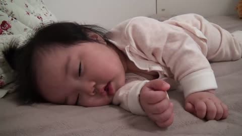 Cute Asian baby Sleeping, then waking up and falling asleep again