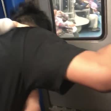 Guy throws up outside of moving subway train door as friend hold him