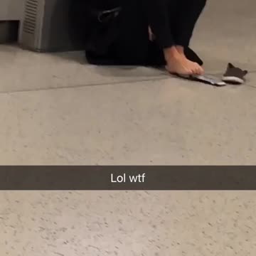 Girl in black sweater typing on phone with feet on floor