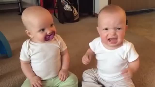 Twin baby girls fight over pacifier