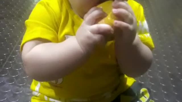 Baby trying to eat Mango