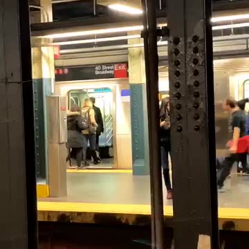 A man with red sweater wrapped around waist dances out of subway