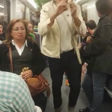 Man in hat plays flute drags toys behind him