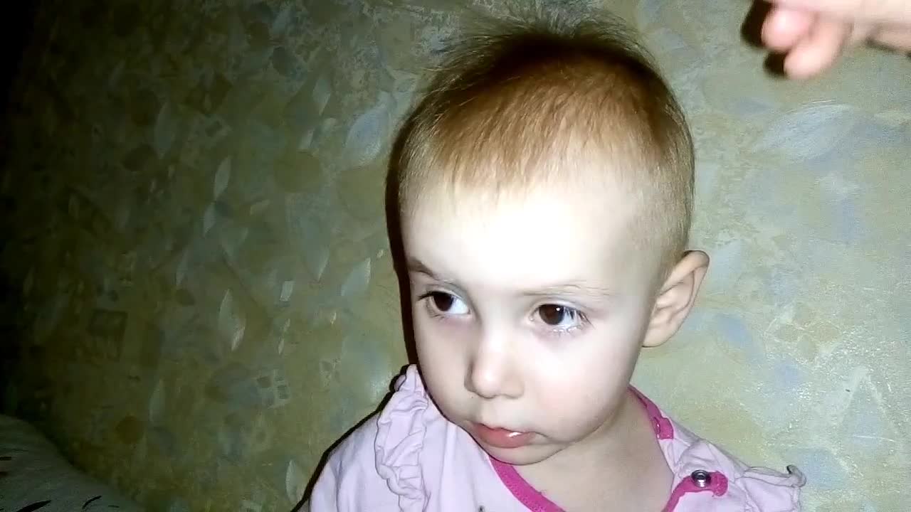 The baby relaxes when her mother brushes her hair.