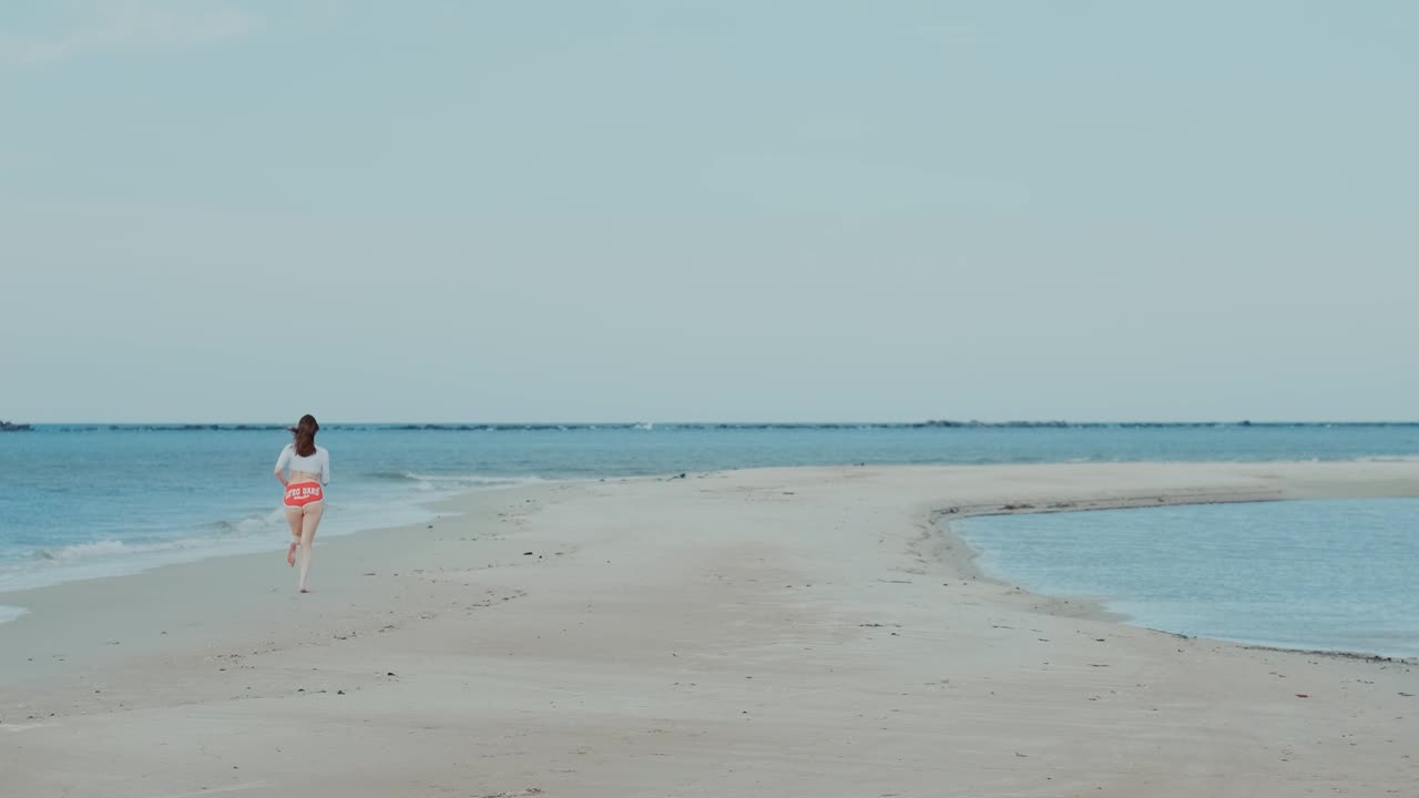 Girl running on sea beach toward sea