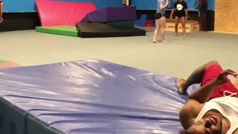 Guy red shorts misses trapeze front flip falls on blue floor