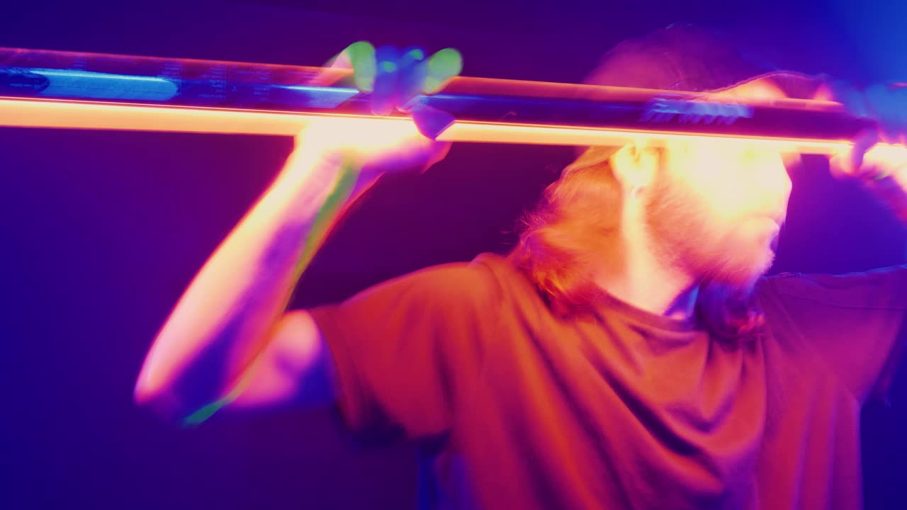 Dancer dancing with a light bar in his hands