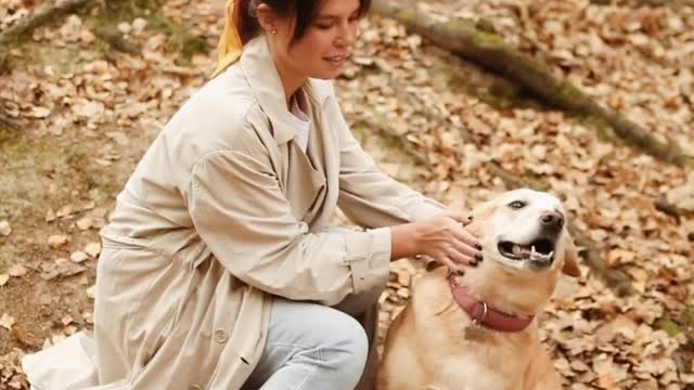 Young woman petting her dog outdoors