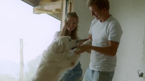 A happy Family playing with thier White dog🤣