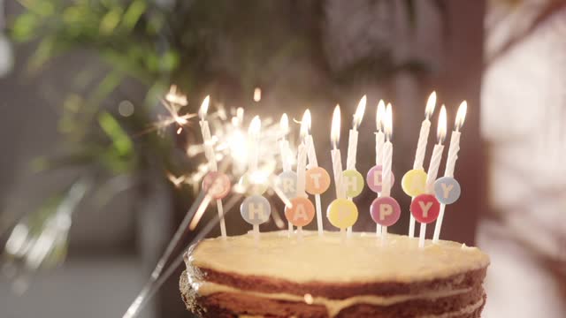 Igniting A Handheld Stick Sparklers From The Candle Of A Birthday Cake