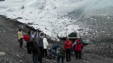 Hikers gather at the base of a glacier for a trek