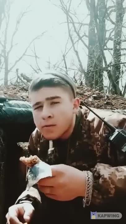 Ukrainian soldier eating snack as Russian artillery is shelling