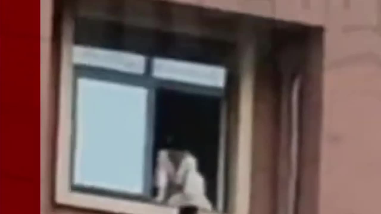 Child plays on high-rise window ledge in China. #Shorts #China #BBCNews