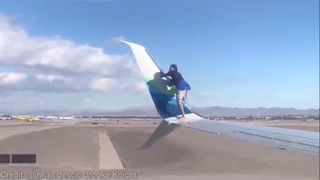 Man Climbs on Side Wing Of The Plane