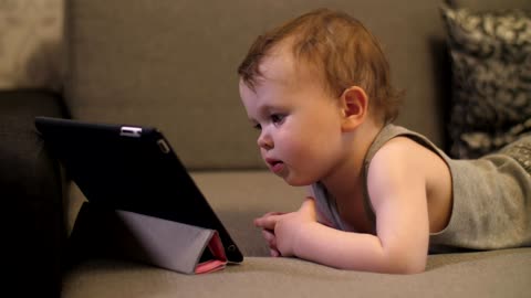 Little baby looking to a video on a tablet